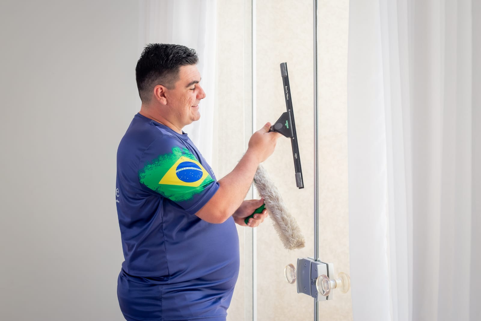 Profissional da L7 Service realizando a limpeza de vidros